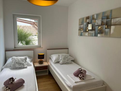 1 dormitorio con 2 camas y ventana en Luxury Apartment Julie, en Vinjerac