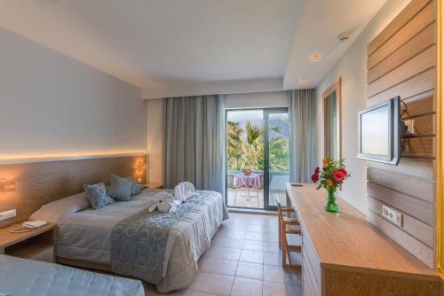 Postel nebo postele na pokoji v ubytování Tigaki Beach Hotel