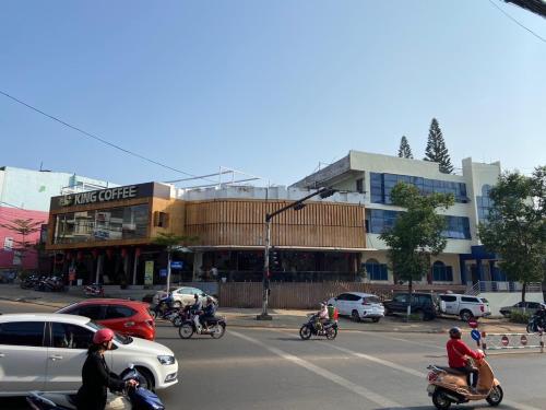 a group of people riding motorcycles on a city street at Hung Vuong Hotel in Pleiku