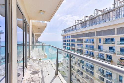 a balcony with chairs and a view of the ocean at RAKvista Beach Residence- Marjan Island in Ras al Khaimah