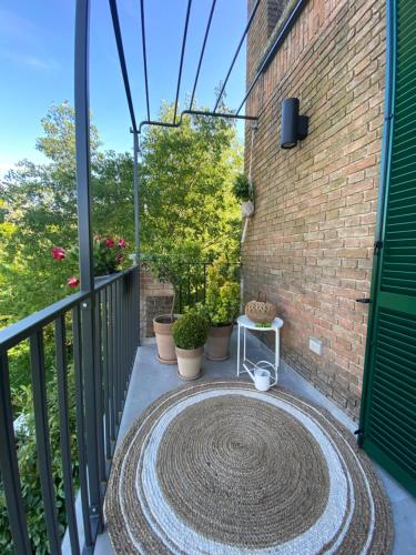 a patio with a large rug on a balcony at Tenuta Pizzone Wine Resort in Rivanazzano