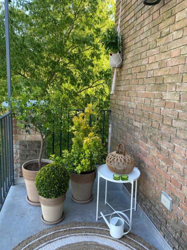 a patio with a table and some plants and a brick wall at Tenuta Pizzone Wine Resort in Rivanazzano