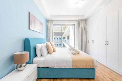 - une chambre bleue avec un lit et une fenêtre dans l'établissement Luxury 1BR Beachfront Apartment Marjan Island, à Ras al Khaimah