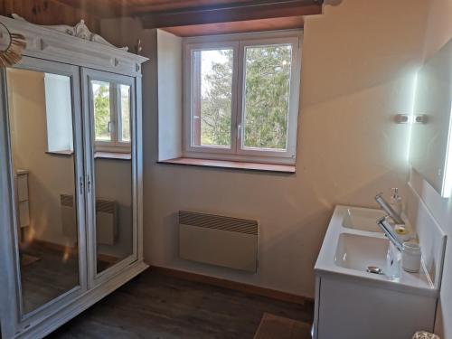 ein Bad mit einer Dusche, einem Waschbecken und einem Fenster in der Unterkunft Gite des Cotes de Sioule in Lisseuil