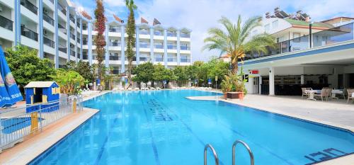 a large swimming pool in front of a hotel at Gazipasa Star Otel in Side