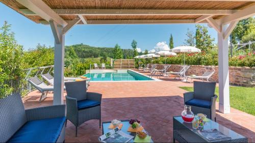 eine Terrasse mit Stühlen und einem Pool in der Unterkunft DIMORA SAN JACOPO 20&1, Emma Villas in Palaia