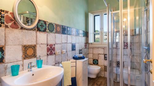 uma casa de banho com um lavatório e um chuveiro com um espelho. em DIMORA SAN JACOPO 20&1, Emma Villas em Palaia