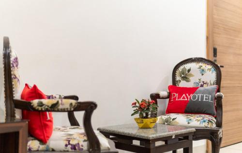 a living room with a chair and a table at Playotel Resort Bhopal in Bhopal