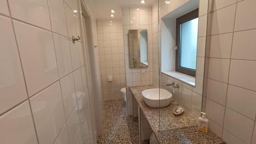 a bathroom with a sink and a toilet and a mirror at ATARAXIA at Saravari Beach - Olive House in Áyios Aléxandros