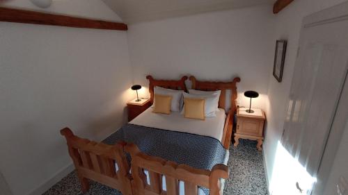 a bedroom with a wooden bed with two lamps at ATARAXIA at Saravari Beach - Olive House in Áyios Aléxandros