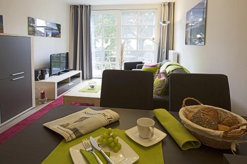 uma sala de estar com uma mesa e uma sala de estar com uma sala de estar em Residenz am Balmer See - FeWo 19 em Balm