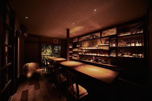 a bar with a row of bar stools in a room at Kagurazaka Retro BAR & HOTEL in Tokyo