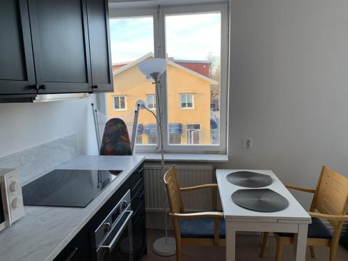 une cuisine avec une table et des chaises ainsi qu'une fenêtre dans l'établissement Apartment in Bromma close to Stockholm City, à Stockholm