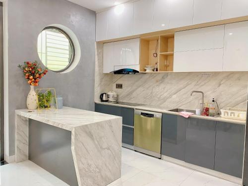 a kitchen with white and blue cabinets and a counter at Aurora Homestay Quảng Ngãi in Quang Ngai