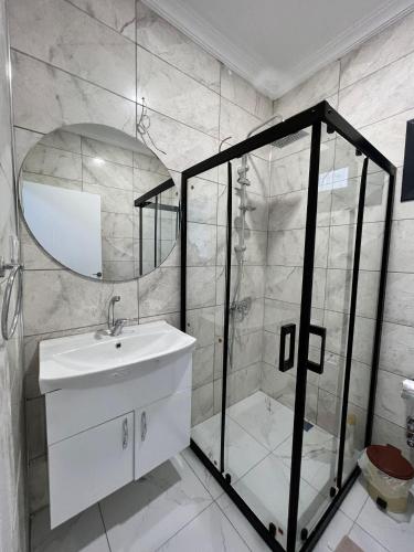a bathroom with a shower and a sink and a mirror at Olympos Bungalov & Villa in Dalaman