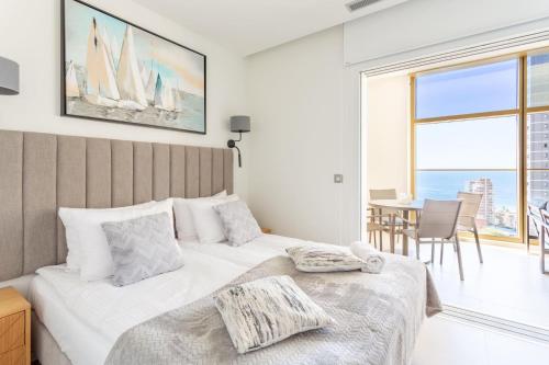 a bedroom with a large bed and a table with chairs at Intempo Sky Apartments 056 in Benidorm