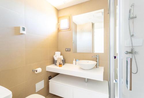 W łazience znajduje się umywalka, toaleta i lustro. w obiekcie Intempo Sky Apartments 056 w mieście Benidorm