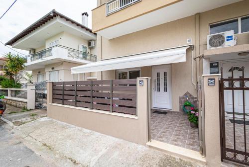 a house with a wooden gate and a door at Marialena Apartment by RentalsPro - Nea Moudania in Nea Moudania