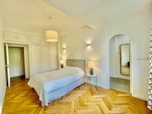 una camera bianca con letto e specchio di Beautiful apartment In historic center a Lisbona