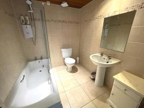 a bathroom with a toilet and a tub and a sink at Beautiful 4BR Period Home With Spectacular Views in Kippford