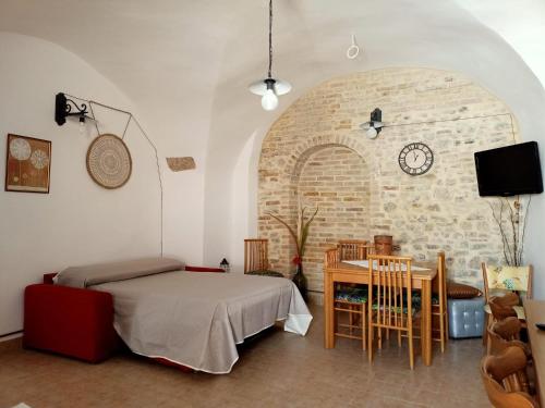 1 dormitorio con cama, mesa y reloj en La casina di Alicia, en Montenero di Bisaccia
