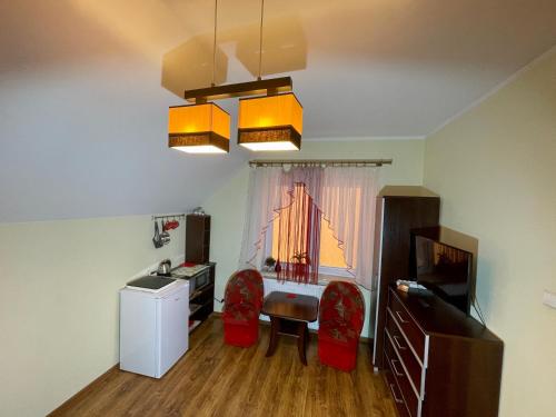 a living room with a table and chairs and a television at Red Rose in Władysławowo