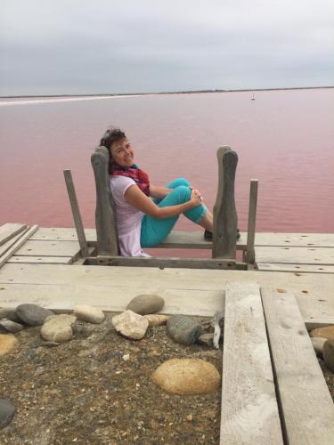 a woman sitting on a dock near the water at Maébrilu Camargue Provence in Salin-de-Giraud