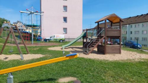 un parque infantil con tobogán y columpio en Ferienwohnung August 24, en Gelenau