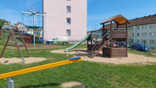 a playground with a slide and a swing set at Ferienwohnung August 24 in Gelenau