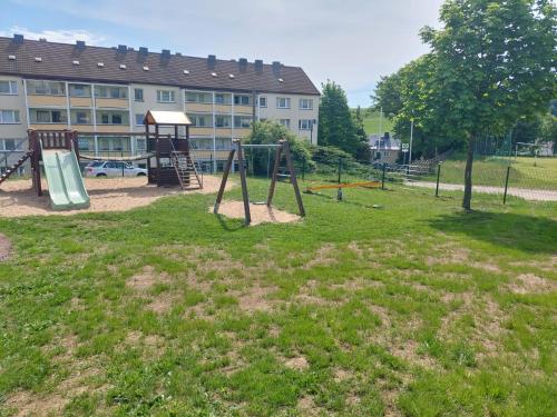 um parque infantil vazio em frente a um edifício em Ferienwohnung August 24 em Gelenau