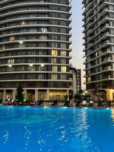 a large swimming pool in front of a large building at Prestigio apart Batumi in Batumi