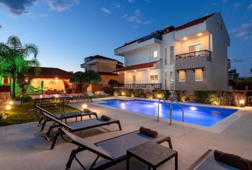 a villa with a swimming pool at night at Emmelia Villa in Ialyssos