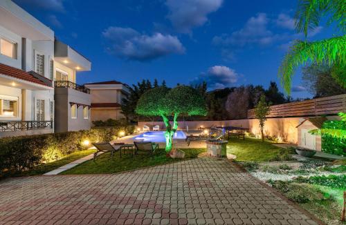 a house with a patio and a tree in the yard at Emmelia Villa in Ialyssos