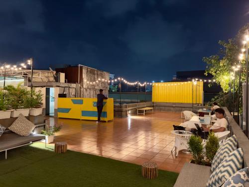 - un toit-terrasse la nuit avec des tables dans l'établissement Locomo Mumbai - Stay Work Eat, à Mumbai