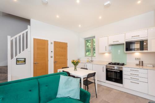 a living room with a couch and a table in a kitchen at Beautiful Honeycomb Cottage in heart of Cotswolds in Chipping Norton