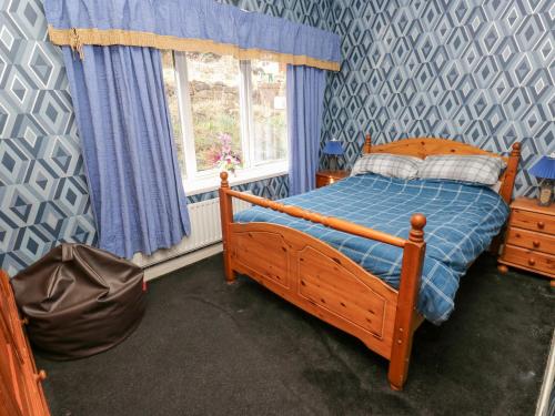 a bedroom with a bed with a blue and gray wall at Call A Mia in Doncaster