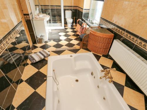 a bathroom with a tub and a checkered floor at Call A Mia in Doncaster