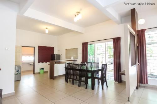 a kitchen and dining room with a table and chairs at De Harmony Stay in Melaka