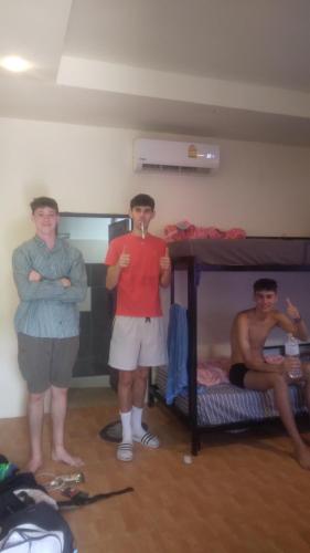 three men standing in a room with a bunk bed at Boy Scouts Homestay in Ban Nua