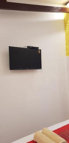 a wall with a television on a white wall at Villa Cinta Family in Gili Trawangan