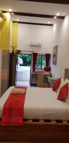 a bedroom with a large white bed with red pillows at Villa Cinta Family in Gili Trawangan