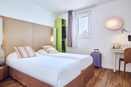 a hotel room with two beds and a window at Campanile Valence Nord - Bourg-Les-Valence in Bourg-lès-Valence