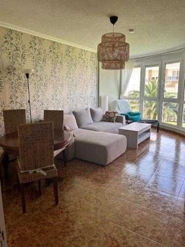 uma sala de estar com um sofá e uma mesa em Playa de Berria - Precioso Apartamento con piscina, Garaje incluido e INTERNET em Santoña