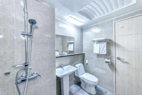 uma casa de banho com um WC, um lavatório e um chuveiro em SH Jungmoon City Stay em Seogwipo