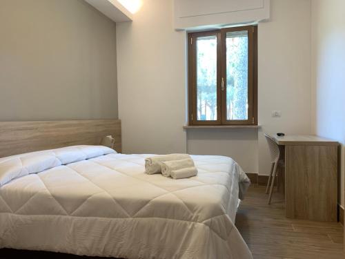 a bedroom with a large white bed and a desk at San Giuseppe Casa per Ferie in Quercianella