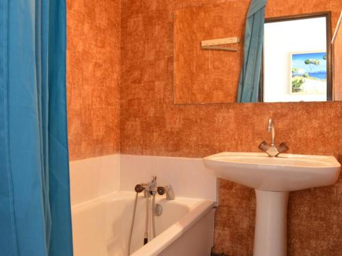 une salle de bain avec un lavabo, un miroir et une baignoire dans l'établissement Appt familial avec piscine, parking à 700m de la plage - FR-1-229D-8, à Saint Pierre La Mer