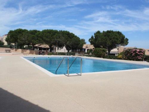 une piscine vide avec des arbres en arrière-plan dans l'établissement Appt familial avec piscine, parking à 700m de la plage - FR-1-229D-8, à Saint Pierre La Mer