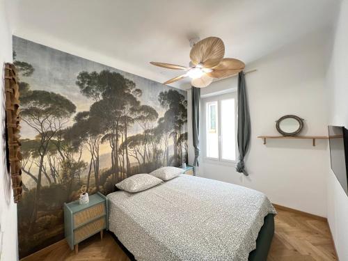 a bedroom with a painting of trees on the wall at Appart Port Cassis Village Parking in Cassis