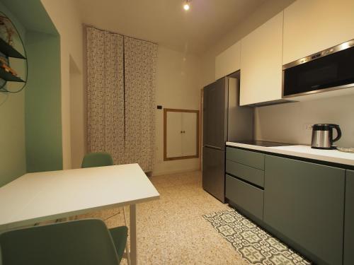 une cuisine avec un comptoir, une table et des chaises dans l'établissement From Pedrotti, à Desenzano del Garda