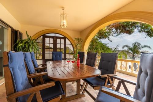 a dining room with a wooden table and chairs at Casa Sapo Gordo in Luz